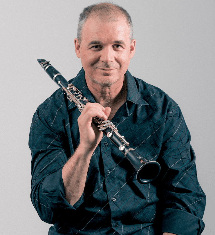 Andy Firth smiling with clarinet over his right shoulder