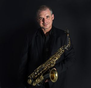 Andy Firth with alto sax around neck